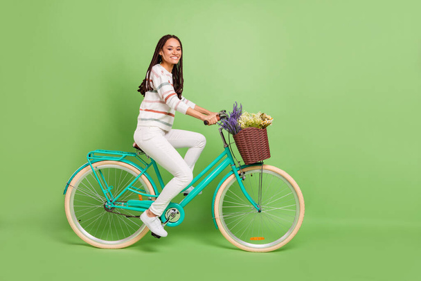 Full size profile side photo of young black girl happy positive smile ride bicycle vehicle trip isolated over green color background - Foto, Bild