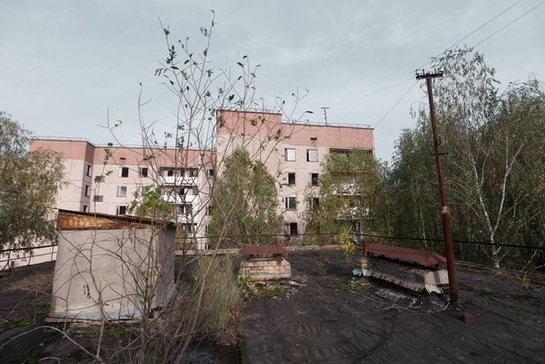 Στέγη σε εγκαταλελειμμένη πόλη φάντασμα Pripyat, μετα αποκαλυπτική πόλη, φθινοπωρινή εποχή στη ζώνη αποκλεισμού του Τσερνομπίλ, Ουκρανία - Φωτογραφία, εικόνα