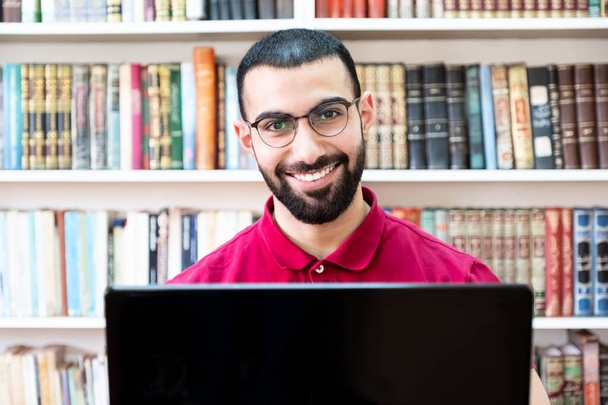 Uomo arabo che utilizza un computer portatile durante conferenze o riunioni per studiare e insegnare attraverso i canali online - Foto, immagini