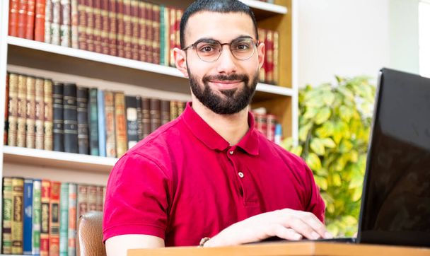 Uomo arabo che utilizza un computer portatile durante conferenze o riunioni per studiare e insegnare attraverso i canali online - Foto, immagini