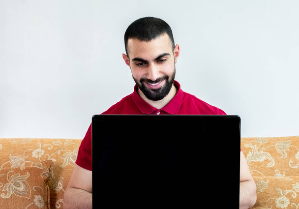 Άραβας που χρησιμοποιεί φορητό υπολογιστή κατά τη διάρκεια συνεδρίων ή συναντήσεων για μελέτη και διδασκαλία μέσω διαδικτυακών καναλιών - Φωτογραφία, εικόνα