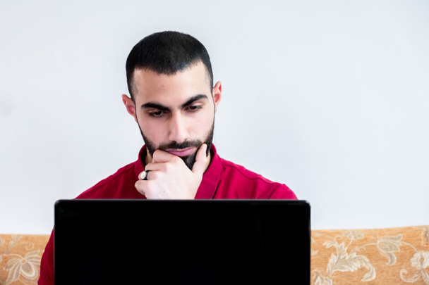 Άραβας που χρησιμοποιεί φορητό υπολογιστή κατά τη διάρκεια συνεδρίων ή συναντήσεων για μελέτη και διδασκαλία μέσω διαδικτυακών καναλιών - Φωτογραφία, εικόνα