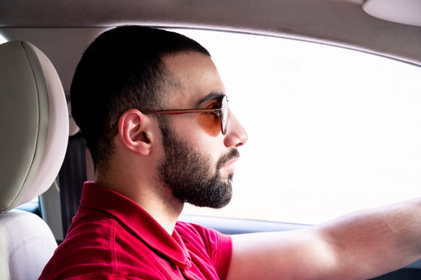 Арабський чоловік їхав машиною з усмішкою і почуттям впевненості. - Фото, зображення