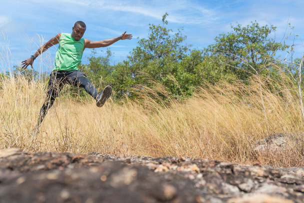african american male trail runner jumping on running on trail outdoors on mountain in summer maraton racing sport for wellbeing - Foto, Imagem
