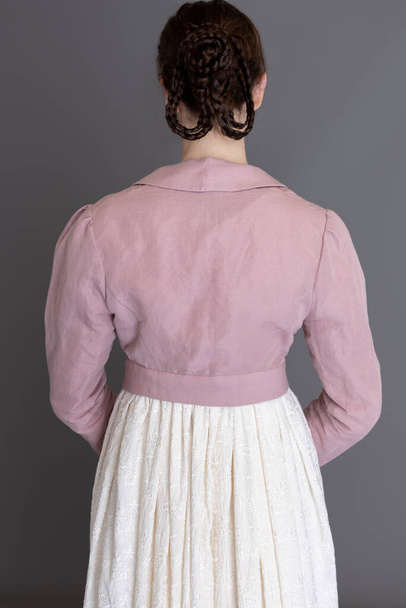 Regencia mujer con un vestido de crema bordado y un spencer de lino rosa - Foto, Imagen