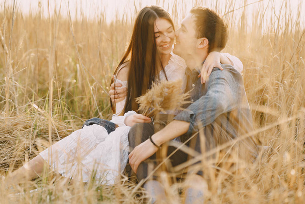 Happy couple in love in wheat field at sunset - 写真・画像