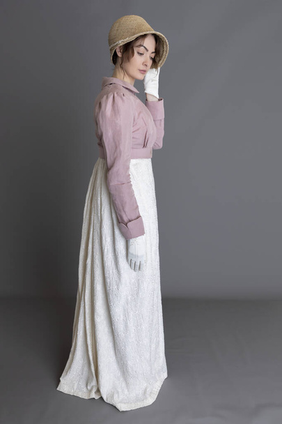 Regencia mujer con un vestido de crema bordado y un spencer de lino rosa - Foto, imagen