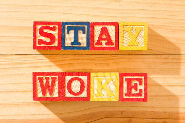 Espectacular cubos de madera con la palabra STAY WOKE en una superficie de madera. - Foto, imagen