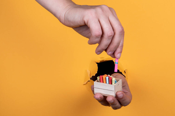 Miniature wooden box with rolls of paper on a yellow background. Data storage and security concept - Valokuva, kuva