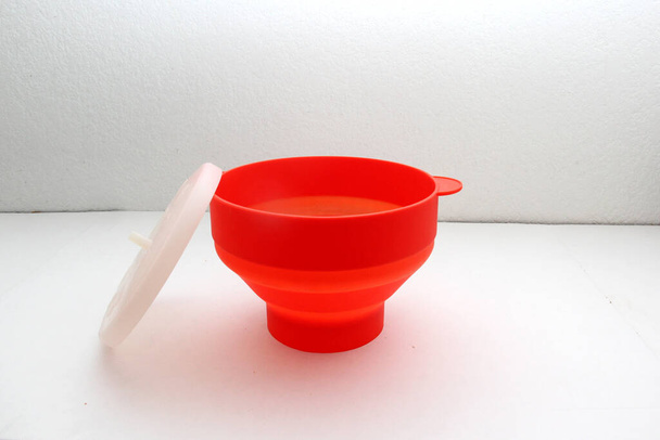 Összecsukható piros szilikon tartály mikrohullámú popcornhoz - Fotó, kép