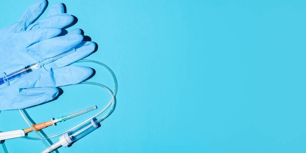Medical equipment, top view. Syringe, gloves, dropper on a blue background, flat lay. Medical banner - Foto, Imagen