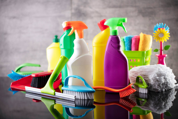 Summer house and office cleaning. Colorful set of bottles with clining liquids and colorful cleaning kit on the gray tiles background. - Foto, afbeelding