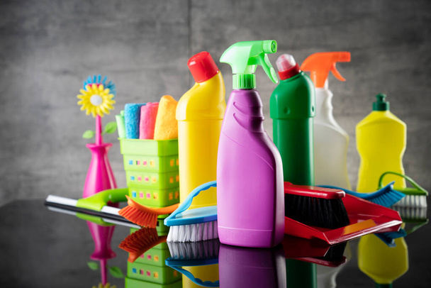 Casa de verano y limpieza de oficinas. Colorido conjunto de botellas con líquidos y kit de limpieza de colores en el fondo de baldosas grises. - Foto, Imagen
