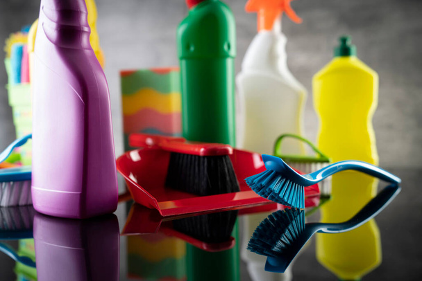 Summer house and office cleaning. Colorful set of bottles with clining liquids and colorful cleaning kit on the gray tiles background. - Foto, immagini
