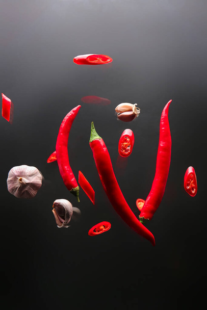 Čerstvé chilli papričky a česnek na tmavém pozadí - Fotografie, Obrázek