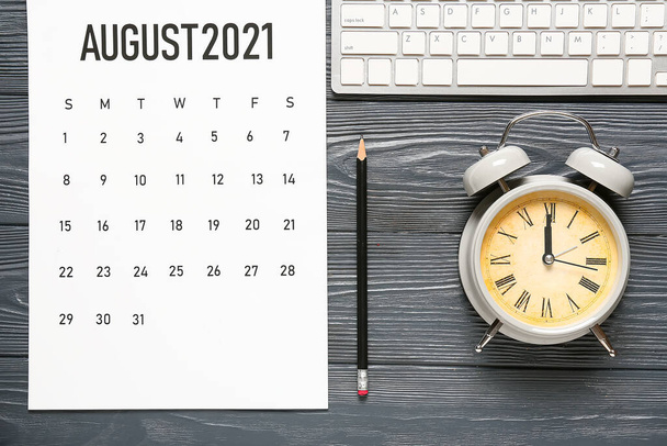 Flip Paper Kalender, Wecker, Tastatur und Bleistift auf dunklem Holzhintergrund - Foto, Bild