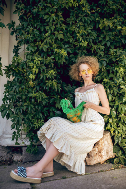 Cute woman in sunglasses on the greenery background - Valokuva, kuva