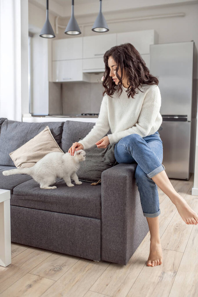 Cute young woman feeding her cat and feeling peaceful - Foto, Bild