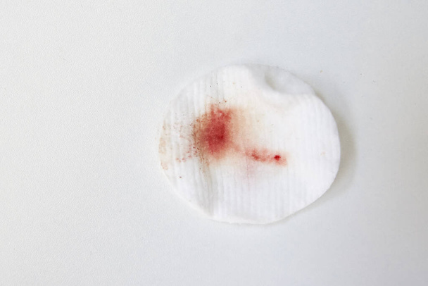 Cotton wool with blood stain on white background - Photo, Image