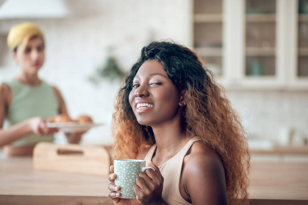 Happy smiling african american woman with coffee and girlfriend - Φωτογραφία, εικόνα