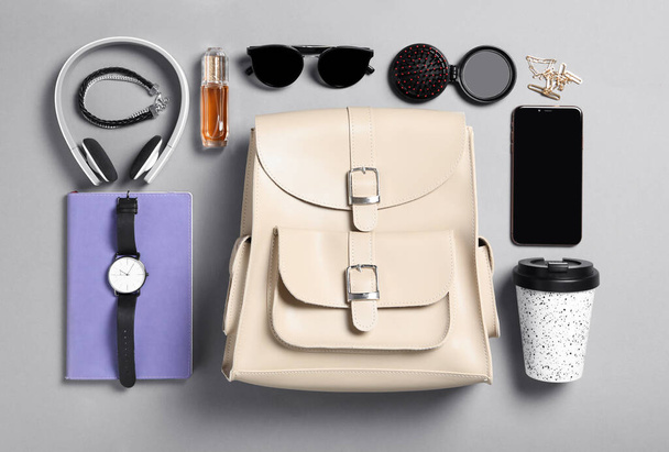 Stylish urban backpack with different items on grey background, flat lay - Photo, image