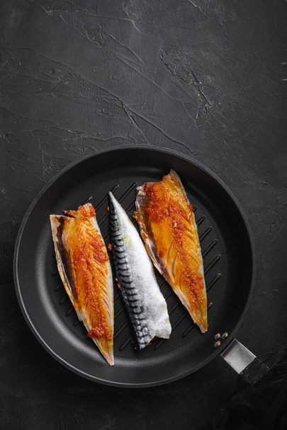 Marinated mackerel on grill pan on black background, top view with copy space. - Фото, зображення