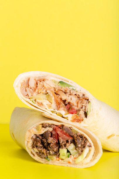 Doner roll shawarma with chicken and vegetables on yellow - Fotó, kép