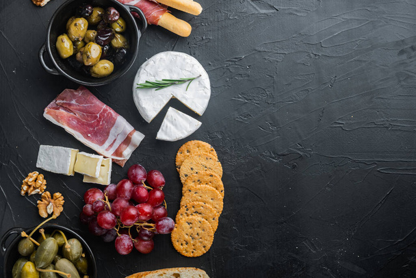 Collations italiennes, fromage à la viande, ensemble d'herbes, sur fond noir, plat avec espace de copie pour le texte - Photo, image