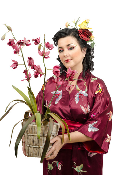 Kimono woman holding wicker pot of orchid - Photo, Image