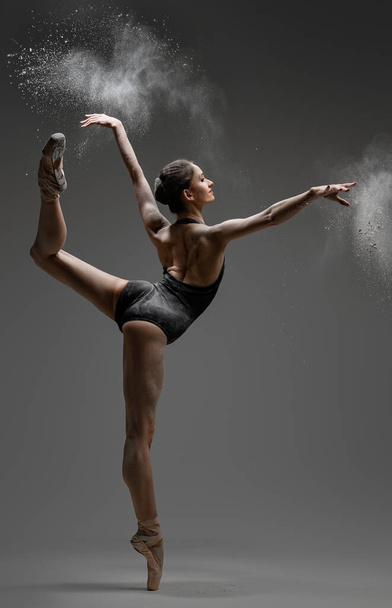 Artistic ballerina wearing black activewar and dancing - Фото, изображение