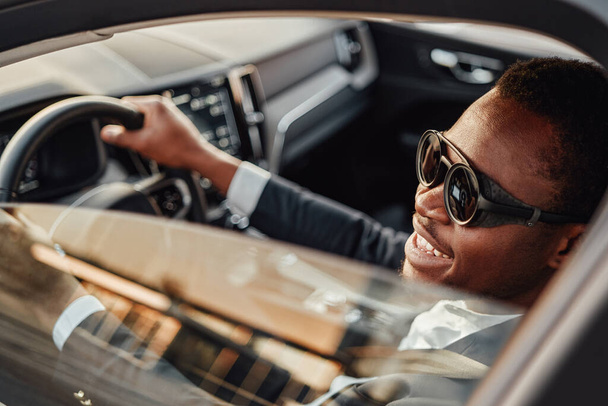 Joyful afroamericano hombre de negocios dentro de coche - Foto, Imagen