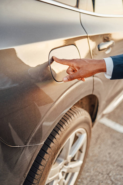 Liikemiehen laukaus sormi auton polttoainesäiliössä - Valokuva, kuva