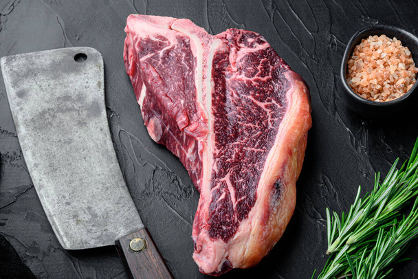 Syrový kostní steak se složkami set, na černém kamenném pozadí, horní pohled byt ležel - Fotografie, Obrázek