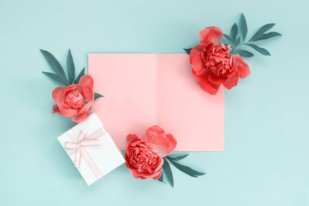 Bouquet of beautiful pink peonies with gift boxes in wrapping paper on yellow background. Greeting card for the holiday. Creative background with copy space for text. - 写真・画像