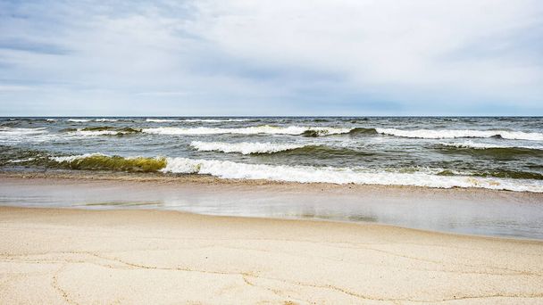Tengeri hullámok a parton és felhős ég - Fotó, kép