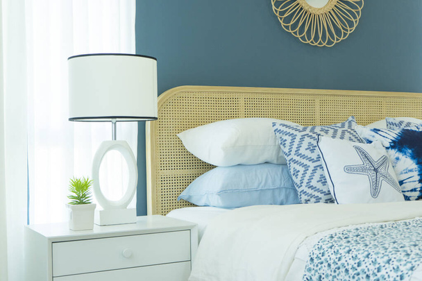 Modern Classic interior bedroom with ethnic decor, lamps over bedside tables, wicker headrest. Blue tone bedroom. - Photo, Image