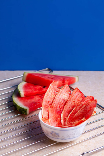 Téli kellékek: szeletek szárított görögdinnye friss darab könnyű háttér rács. - Fotó, kép