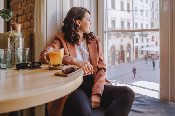 belle femme assise dans un café regardant dans un grand espace de copie de fenêtre - Photo, image