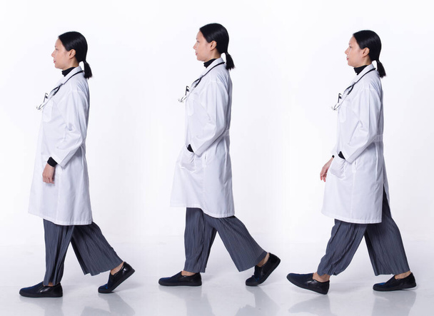 Коллаж Полная длина 40-х годов 50-х Азиатская ЛГБТКИЯ + Доктор Женщина носят халат, стетоскоп, карту пациентов. Медицинская женщина ходить повернуть направо в больнице на белом фоне изолированы - Фото, изображение