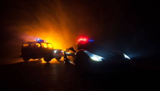 Voiture de police pourchassant une voiture la nuit avec un fond de brouillard. 911 Intervention d'urgence voiture de police accélérant sur les lieux du crime. Décoration créative. Concentration sélective - Photo, image