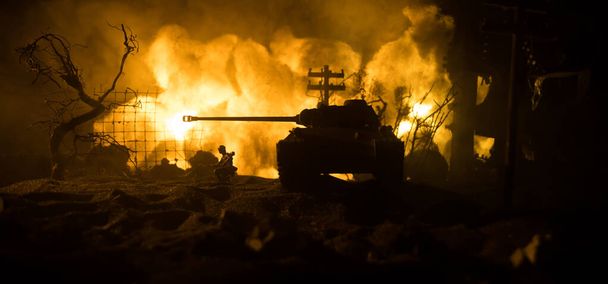戦争の概念。戦場の霧の空を背景にした軍のシルエット、曇ったスカイラインの下の世界大戦兵士シルエット夜。装甲車両の戦闘シーン。選択的焦点 - 写真・画像