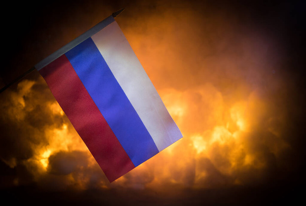 Konzept der Krise des Krieges und der politischen Konflikte zwischen Ländern. Flagge Russlands auf dunklem brennenden Hintergrund. Selektiver Fokus - Foto, Bild