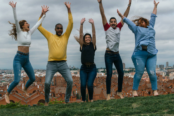Interrassische Freunde springen in einem Park und lachen - Foto, Bild