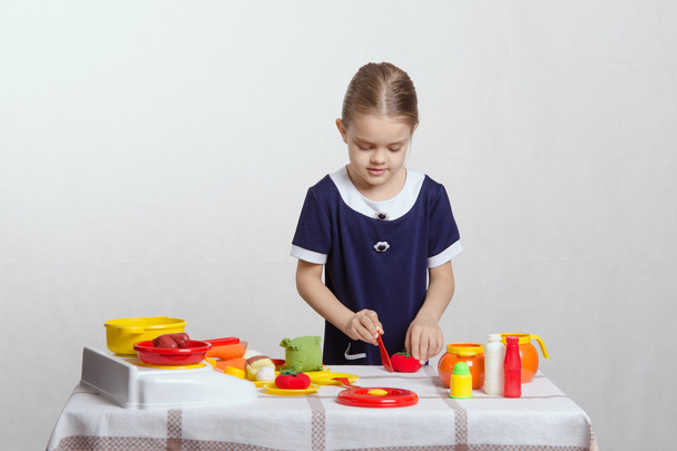 dziewczyna entuzjastycznie kawałki pomidorów - Zdjęcie, obraz
