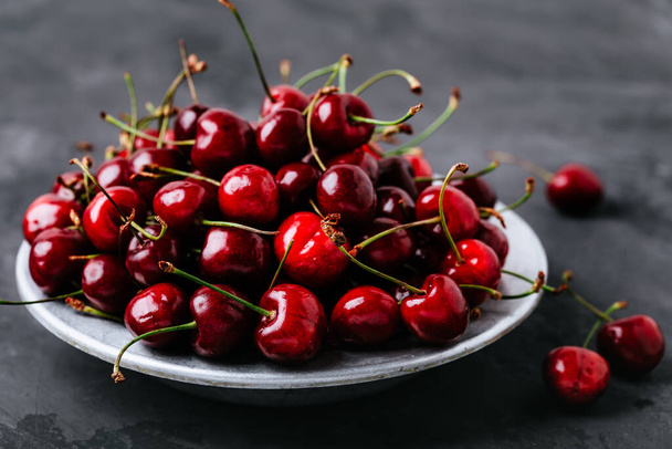 Cherry. Sweet Cherries in bowl on dark stone concrete background. Ripe Sweet Red Cherries. - Photo, Image