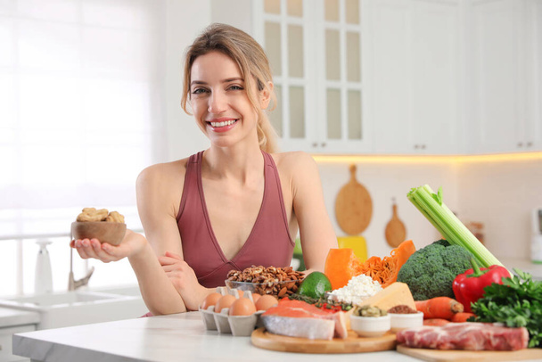 Woman with healthy food in kitchen. Keto diet - Zdjęcie, obraz