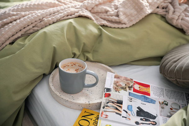 Aromatic coffee and magazines on bed with linens indoors - Φωτογραφία, εικόνα