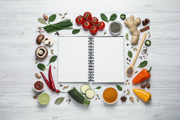 Open recipe book and different ingredients on white wooden table, flat lay. Space for text - Fotoğraf, Görsel