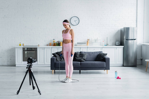 femme sportive avec corde à sauter leçon d'enregistrement sur appareil photo numérique à la maison - Photo, image