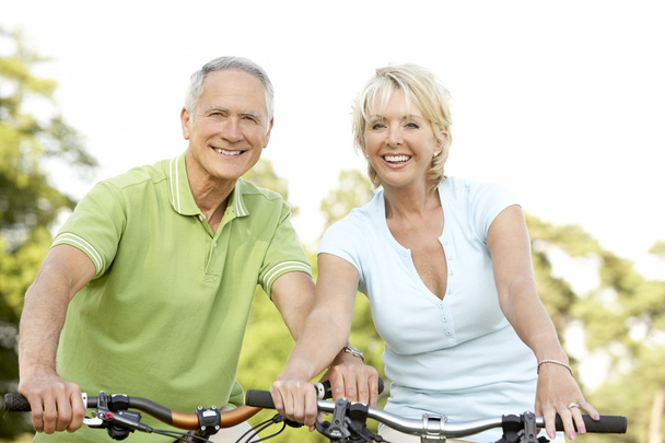 Mature couple riding bikes - Foto, Imagen